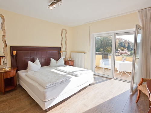 modernes Doppelzimmer mit Boxspingbett und großem Balkon