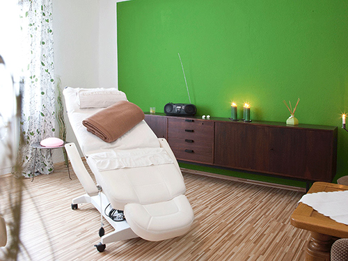 Gemütlich eingerichteter Massagebereich mit Kerzen und Duftstäbchen