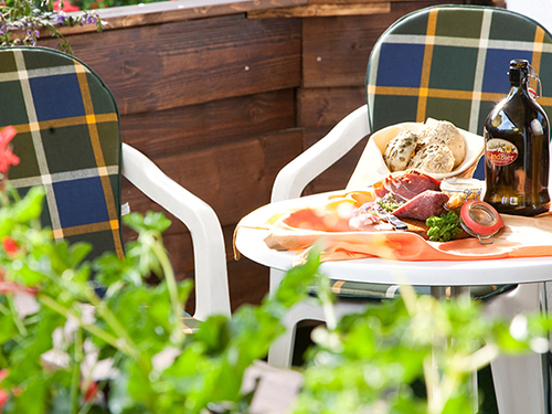Terrasse mit einem kleinen Tisch, Snacks und Getränken sowie zwei Stühlen