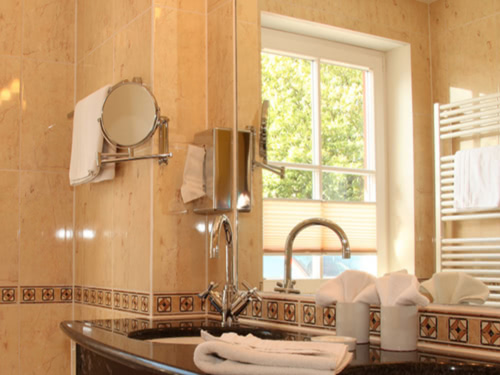 modernes Bad mit Badewanne, zwei Waschbecken, Spiegel, Föhn und Kosmetikspiegel