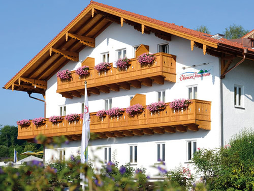 Traditionelles bayerisches Gebäude mit blumengeschmückten Balkonen.