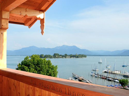 Blick vom Balkon auf den Chiemsee mit Segelbooten und Alpenpanorama