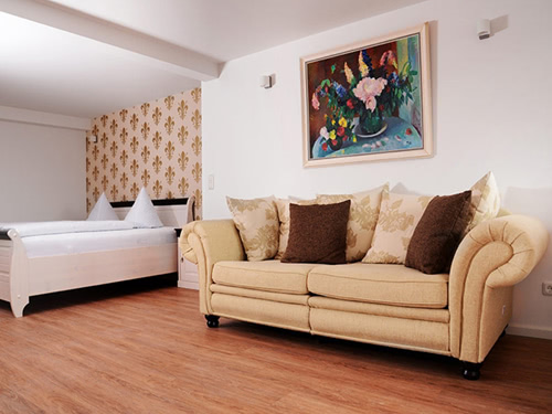 Modernes Schlafzimmer mit beiger Couch und stilvoller Wanddekoration.