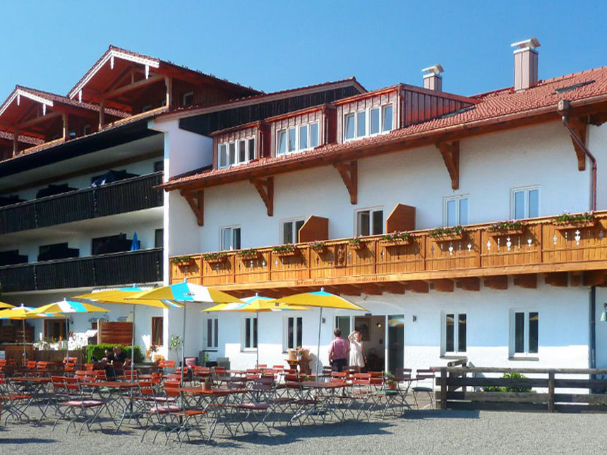 Traditionelles bayerisches Gasthaus mit Sonnenschirmen und Biergarten