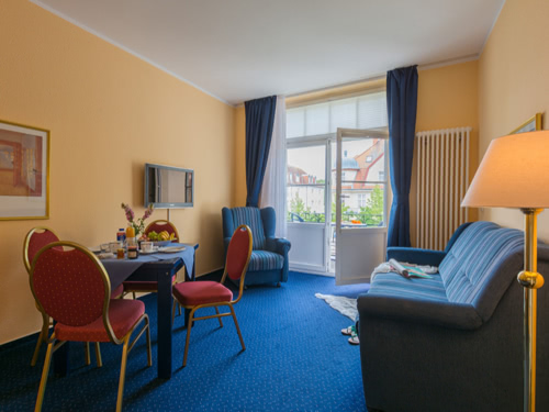 Wohnbereich mit Sessel, Couch, Tischgruppe und Stehlampe