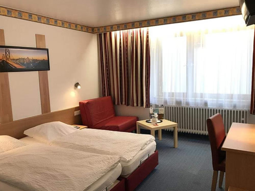 Zweibettzimmer mit kleiner Sitzecke, Schreibtisch und TV