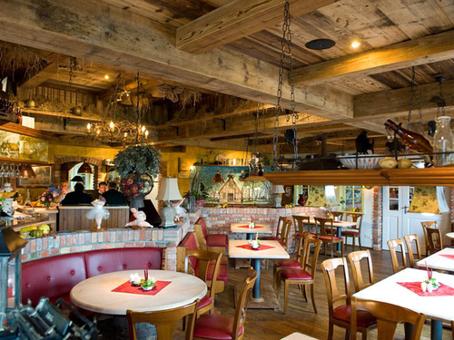 großer Restaurantbereich mit verschiedenen Tischgruppen und Holzoptik