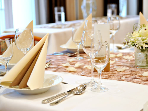 gedeckter Tisch mit Servietten, Besteck, Wein und Wasserglas