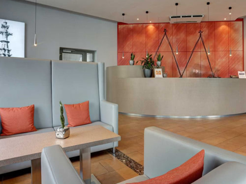 Moderne Lobby in grau rot mit gemütlichen Sitzmöglichkeiten