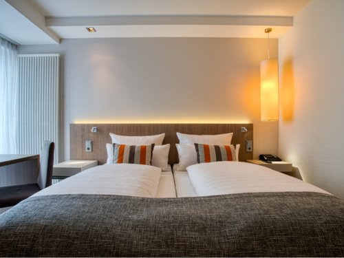 modernes Doppelzimmer mit Schreibtisch und Tagesdecke