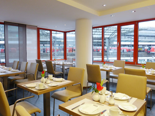Restaurant mit vielen Tischen und Blick auf den Kölner Hauptbahnhof