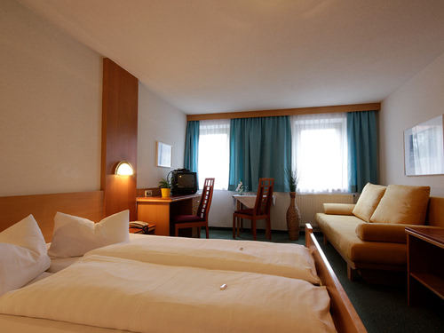 geräumiges Doppelzimmer mit Couch, Schreibtisch, Stuhl und Tisch