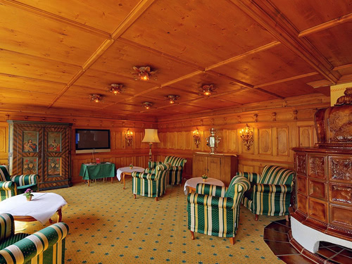 Kaminzimmer des Hotels mit Sesseln, Tischen und Holzofen