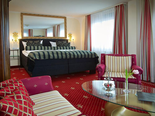 geräumiges Doppelzimmer mit Wahnlandschaft, Tisch und Spiegel über dem Bett