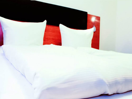 Doppelbett mit weissen Kissen im Expo Hotel Frankfurt am Main
