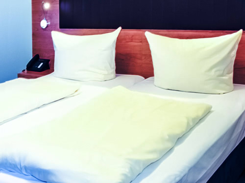 Doppelbett mit Telefon im Expo Hotel Frankfurt am Main