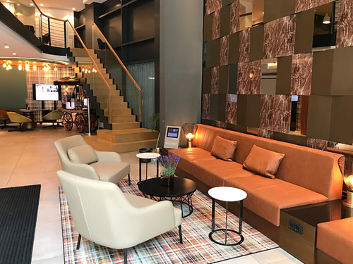 große Lobby mit Treppenaufgang, Couch und Sessel