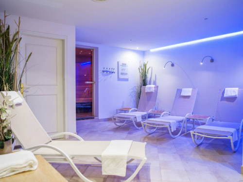 Ruhebereich mit Relaxliegen und Saunaeingang im Hintergrund