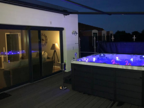 Aussenterrasse mit großem Whirpool am Abend